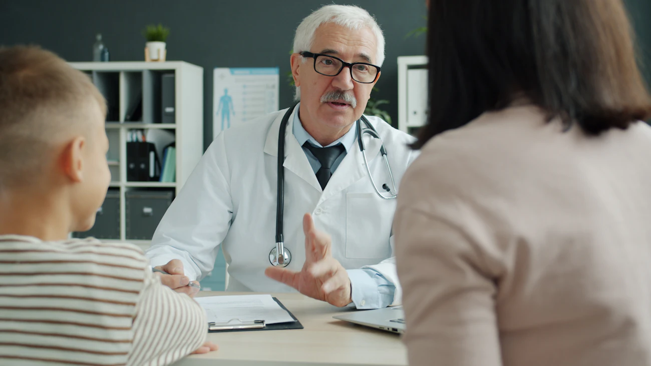 A GP talking with a mother and her young son