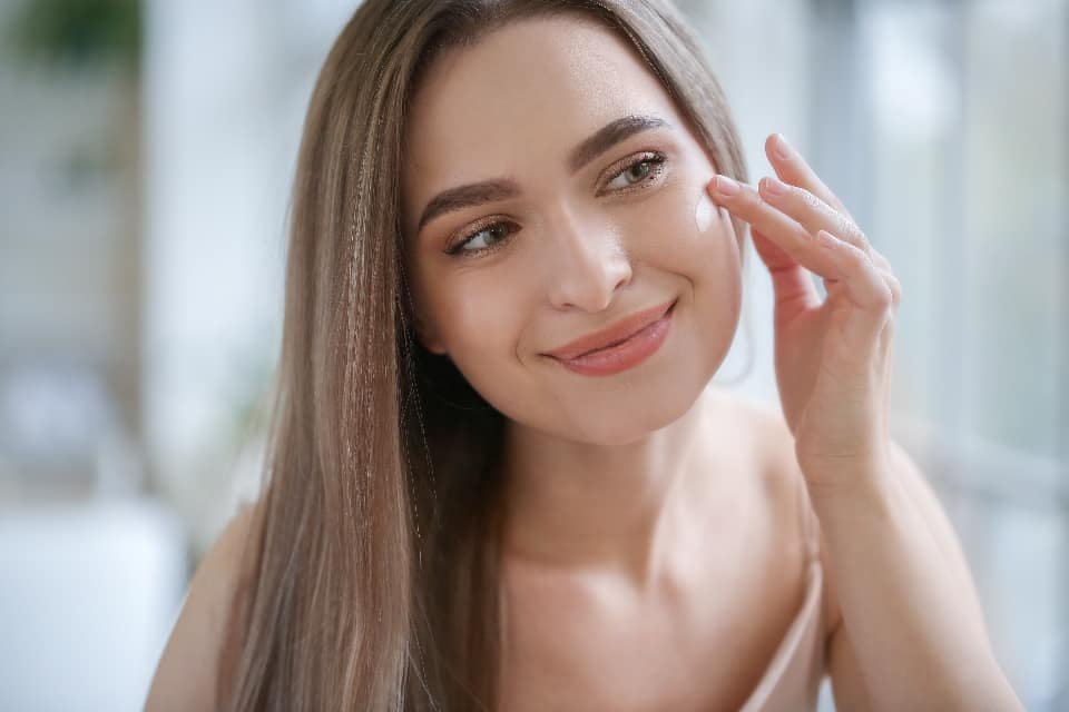Woman applying skincare, representing an online acne treatment review