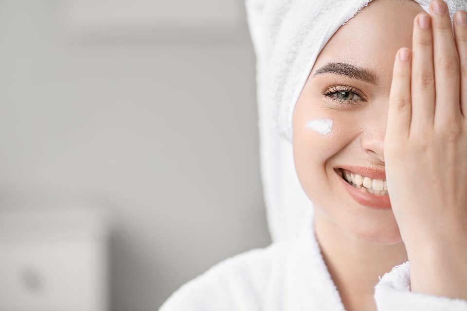 Woman applying moisturiser, representing an eczema and psoriasis flare-up review